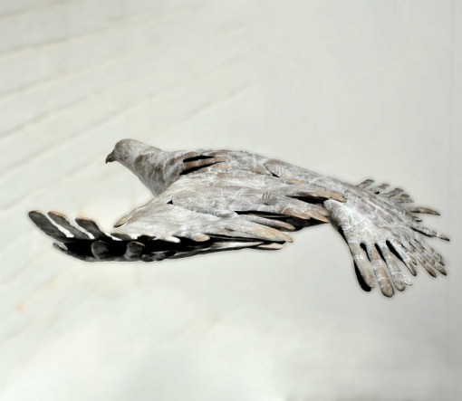 BIRD IN HAND - a bronze bird in flight made out of hand prints